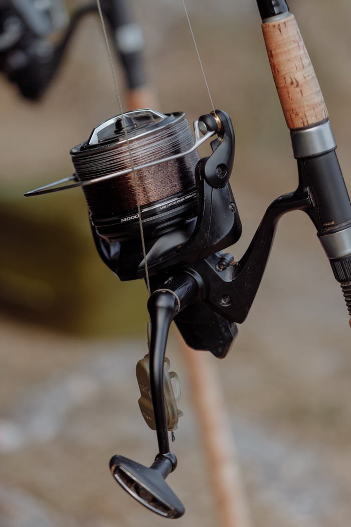 Detailed view of a fishing reel attached to a rod, perfect for angling enthusiasts.